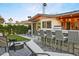 Inviting backyard featuring a fire pit, outdoor kitchen, bar seating, and lush landscaping at 8114 E Arlington Rd, Scottsdale, AZ 85250