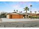 Picture-perfect single-story home featuring desert landscaping, modern garage doors, and a covered front porch at 8114 E Arlington Rd, Scottsdale, AZ 85250