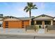 Charming single-story home with a modern garage, desert landscaping, and inviting front porch seating at 8114 E Arlington Rd, Scottsdale, AZ 85250