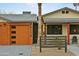 Charming home featuring a modern garage door, desert landscaping, and inviting front porch at 8114 E Arlington Rd, Scottsdale, AZ 85250