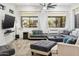 Well-lit living room with a large sectional, ceiling fan and view of the backyard at 8114 E Arlington Rd, Scottsdale, AZ 85250