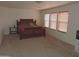 Carpeted main bedroom featuring three windows and a dark wood king bed at 8163 E Posada Ave, Mesa, AZ 85212