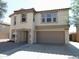 A two-story home with a two-car garage, and a low-maintenance landscape with a paved driveway at 8163 E Posada Ave, Mesa, AZ 85212