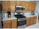 Modern kitchen with stainless steel stove, microwave and wooden cabinets at 8163 E Posada Ave, Mesa, AZ 85212