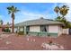 A single story house with white siding, green trim, rock landscaping and palm trees on a sunny day at 848 W Keating Ave, Mesa, AZ 85210