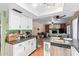 This kitchen with white cabinets opens up to the living room with a fire place, providing an open concept feel at 848 W Keating Ave, Mesa, AZ 85210