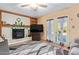 Cozy living room with brick fireplace, ceiling fan, built in shelving, and pool view through the patio doors at 848 W Keating Ave, Mesa, AZ 85210