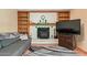 Cozy living room with brick fireplace, built in shelving, a grey couch, and geometric rug at 848 W Keating Ave, Mesa, AZ 85210