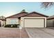 Inviting single-story home featuring a two-car garage, desert landscaping and manicured shrubs at 906 N Roosevelt Cir, Scottsdale, AZ 85257