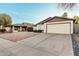 Single-story home with a two-car garage, driveway and low-maintenance desert landscaping at 906 N Roosevelt Cir, Scottsdale, AZ 85257