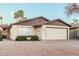 Inviting single-story home featuring a two-car garage, desert landscaping and manicured shrubs at 906 N Roosevelt Cir, Scottsdale, AZ 85257