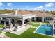 Expansive backyard with a pool, outdoor kitchen, manicured lawn, and mountain views at 10050 N 58Th St, Paradise Valley, AZ 85253