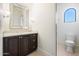 Powder room features a dark wood vanity with marble countertop, an ornate mirror, and toilet in an alcove at 10050 N 58Th St, Paradise Valley, AZ 85253