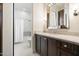 Bathroom with dark wood vanity, large mirror, marble countertop, and shower with curtain at 10050 N 58Th St, Paradise Valley, AZ 85253