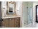 Bathroom boasts a vanity with stone countertop, decorative mirror, sconces, and tiled shower with glass door at 10050 N 58Th St, Paradise Valley, AZ 85253