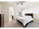 Bedroom featuring neutral walls, carpet, and trim, complemented by a dark wood bedframe and arched doorway to the bathroom at 10050 N 58Th St, Paradise Valley, AZ 85253