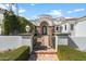 Charming front gate with lush landscaping, brickwork, and an arched entryway at 10050 N 58Th St, Paradise Valley, AZ 85253