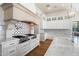 Kitchen featuring a pot filler faucet, custom hood, backsplash, and top-of-the-line appliances at 10050 N 58Th St, Paradise Valley, AZ 85253