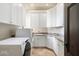 Bright laundry room with white cabinets, granite countertops, stainless steel sink, and modern washer/dryer at 10050 N 58Th St, Paradise Valley, AZ 85253