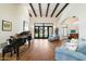 Bright living room features a piano, wooden floors, exposed beam ceiling and ample natural light at 10050 N 58Th St, Paradise Valley, AZ 85253