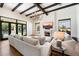 Bright living room featuring a stone fireplace, wood beams, a chandelier, and floor-to-ceiling windows at 10050 N 58Th St, Paradise Valley, AZ 85253