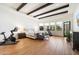 Bright main bedroom with dark wood beam ceiling, hardwood floors and exercise equipment at 10050 N 58Th St, Paradise Valley, AZ 85253