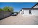 View of the home's backyard with privacy wall, brick pavement, and parking at 10105 E Cactus Rd, Scottsdale, AZ 85260