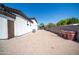 Backyard of the property with a brick paved driveway and a privacy wall at 10105 E Cactus Rd, Scottsdale, AZ 85260