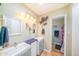 Well-lit bathroom with dual sinks, decorative mirrors, and modern fixtures at 10105 E Cactus Rd, Scottsdale, AZ 85260