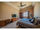 A spacious bedroom with a ceiling fan, neutral tones, and a large window at 10105 E Cactus Rd, Scottsdale, AZ 85260