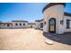 Unique home featuring a stucco exterior, a curved entryway, a courtyard, and mature desert landscaping at 10105 E Cactus Rd, Scottsdale, AZ 85260