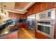 Features a modern kitchen with stainless steel appliances, granite countertops, and custom wood cabinetry at 10105 E Cactus Rd, Scottsdale, AZ 85260