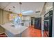Bright kitchen with white cabinets, modern appliances, a skylight, and hardwood floors at 10105 E Cactus Rd, Scottsdale, AZ 85260