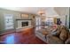 Cozy living room with hardwood floors, a brick fireplace, and direct access to the kitchen at 10105 E Cactus Rd, Scottsdale, AZ 85260