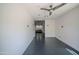 An open room with black floors, a ceiling fan, and a view to an adjacent bedroom at 10105 E Cactus Rd, Scottsdale, AZ 85260