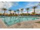 Lovely community pool with steps and handrail for easy access, surrounded by lounge chairs and swaying palm trees at 10156 E Radiant Ave, Mesa, AZ 85212