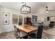 Elegant dining room with a modern chandelier, a wooden table, and view to the living room at 10156 E Radiant Ave, Mesa, AZ 85212