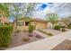 Inviting single level home with a paver driveway, beautiful landscaping, and lush trees at 10156 E Radiant Ave, Mesa, AZ 85212
