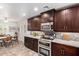 Well-lit kitchen with modern appliances, dark wood cabinetry, eat-in breakfast nook, and light countertops at 10156 E Radiant Ave, Mesa, AZ 85212
