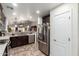 Spacious kitchen with stainless steel appliances, dark wood cabinetry, and eat-in counter in the background at 10156 E Radiant Ave, Mesa, AZ 85212