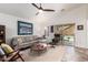 Bright living room featuring a vaulted ceiling, stylish furniture, and view of the pool through sliding glass doors at 10156 E Radiant Ave, Mesa, AZ 85212