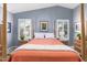 Bright bedroom with a four-poster bed, plantation shutters, and views of the surrounding landscape at 10156 E Radiant Ave, Mesa, AZ 85212