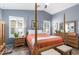 Cozy main bedroom with a four-poster bed, light blue walls, and plantation shutters at 10156 E Radiant Ave, Mesa, AZ 85212