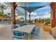 Outdoor dining area with tables, chairs, grill, and shade offering a relaxed community space for residents at 10156 E Radiant Ave, Mesa, AZ 85212