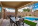 Inviting covered patio with a dining table, grill, and view of the refreshing pool and landscaped backyard at 10156 E Radiant Ave, Mesa, AZ 85212