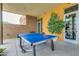 A covered outdoor patio with a ping pong table and greenery at 10156 E Radiant Ave, Mesa, AZ 85212