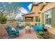 Relaxing outdoor patio with comfortable seating, vibrant blue cushions, and decorative plants at 10156 E Radiant Ave, Mesa, AZ 85212