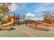 Community playground showcasing play structures, climbing apparatus and a shady seating area at 10156 E Radiant Ave, Mesa, AZ 85212