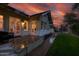 Exterior view of home with patio, green lawn, and manicured landscaping against a dramatic sunset backdrop at 102 W Almeria Rd, Phoenix, AZ 85003
