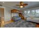 Comfortable bedroom featuring a bunk bed, seating area, a ceiling fan, and large windows for natural light at 102 W Almeria Rd, Phoenix, AZ 85003